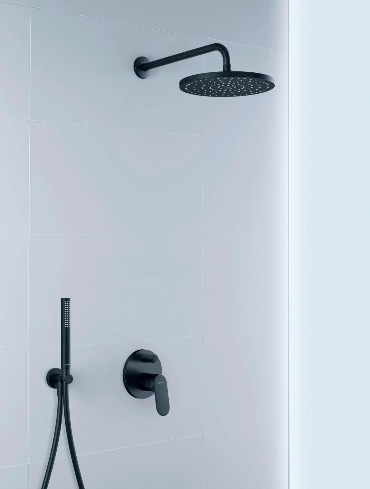 Schwarze Duscharmatur an weißer Wand. Moderne Badezimmerausstattung.