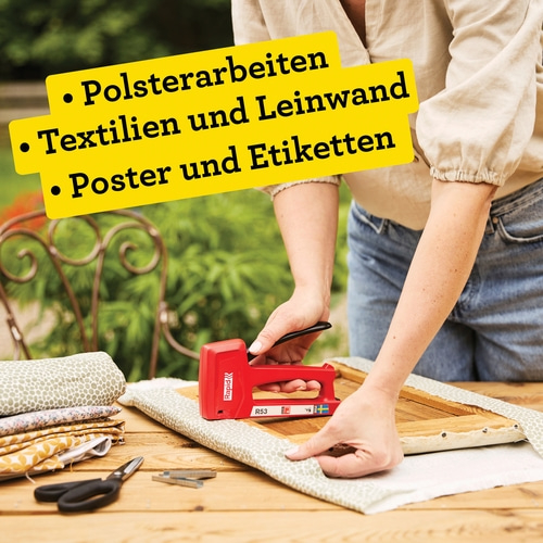 Person polstert mit rotem Tacker ein Holzobjekt mit Stoff.