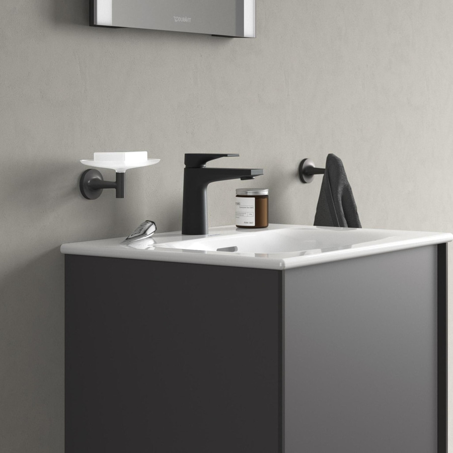 Badezimmer mit Waschbecken, Wasserhahn, Seifenschale, Handtuchhalter und Kerze