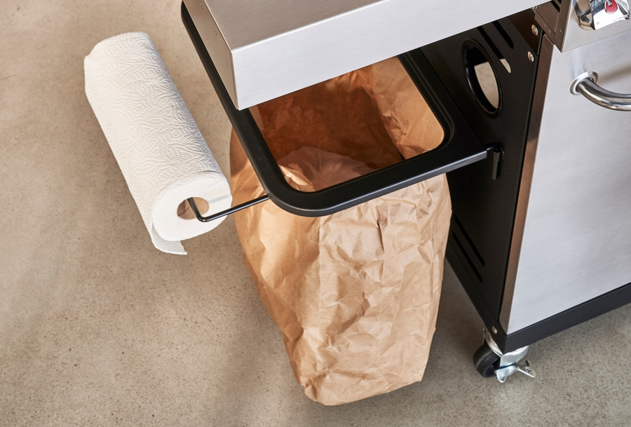 Papierhandtuchrolle und Papiertüte an einem Grillwagen auf Betonboden