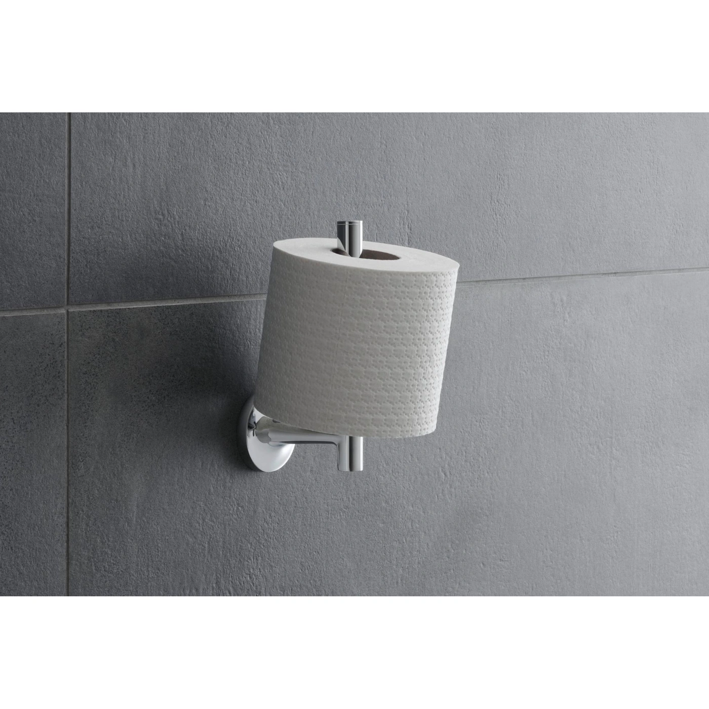 Toilettenpapierhalter mit einer Rolle Toilettenpapier an einer grauen Wand.