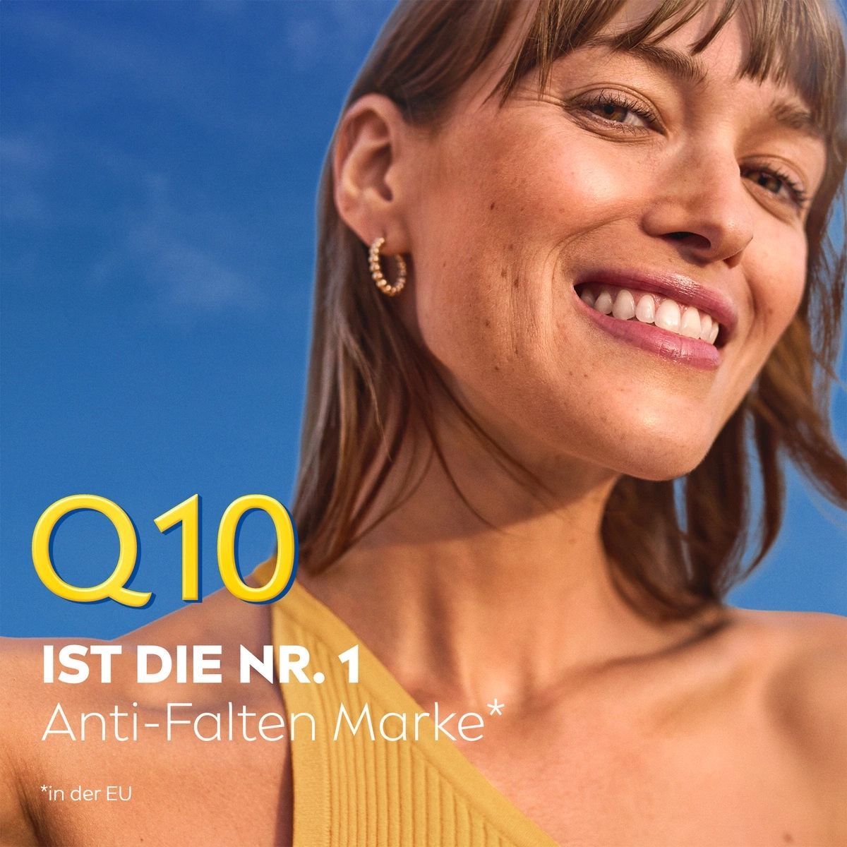 Frau lächelt mit Q10-Werbung. Anti-Falten Marke in der EU. Blauer Hintergrund.