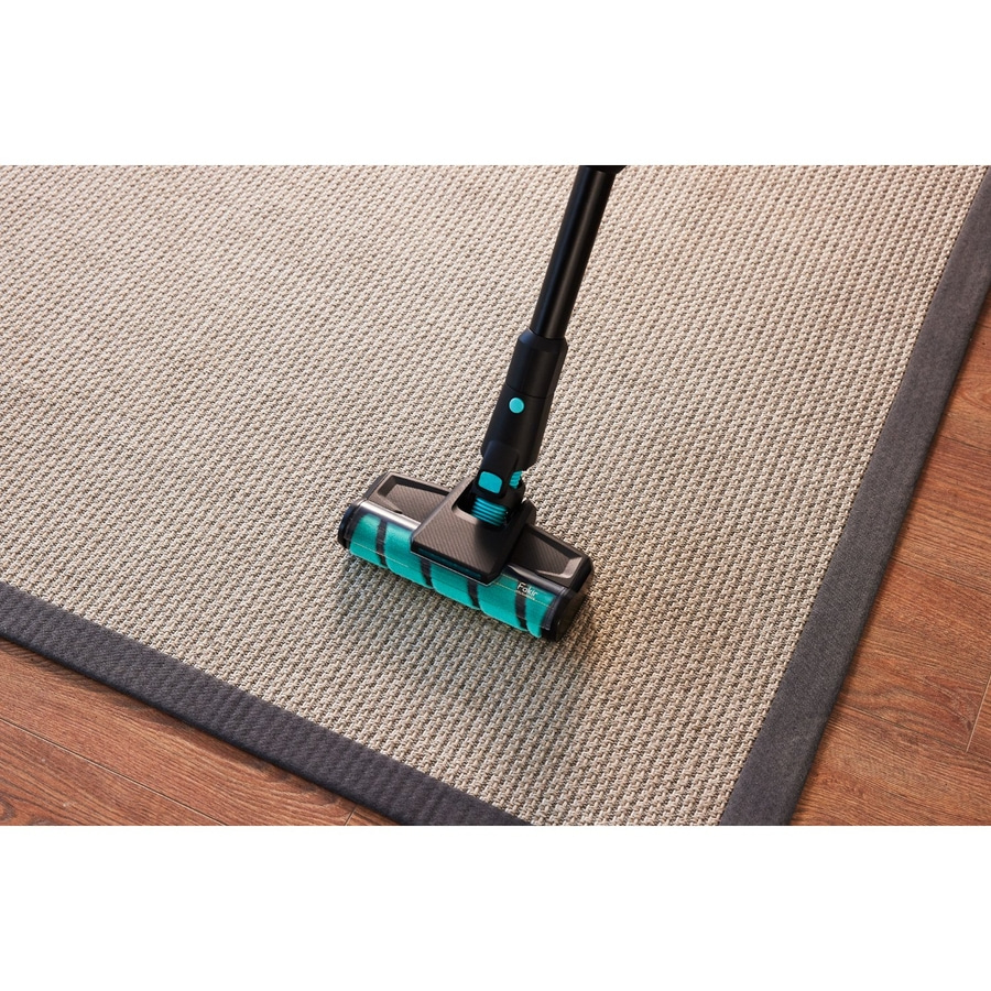Ein Staubsaugerreiniger mit Bürste reinigt einen Teppich.