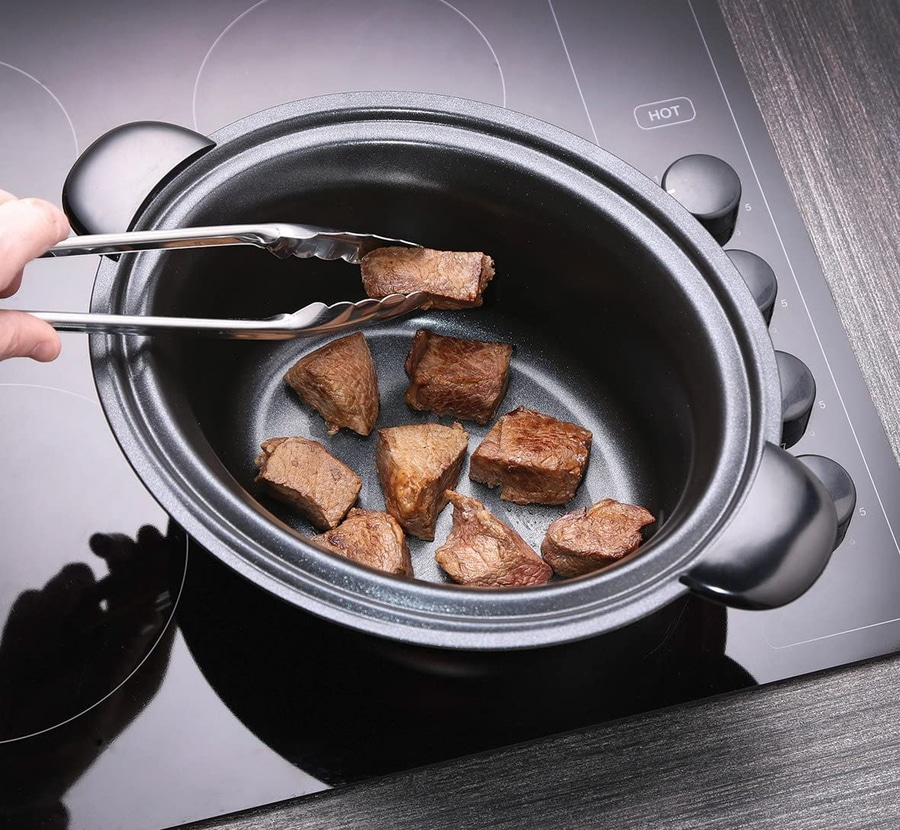 Fleischstücke in einem Topf mit Zange. Kochen auf dem Herd.