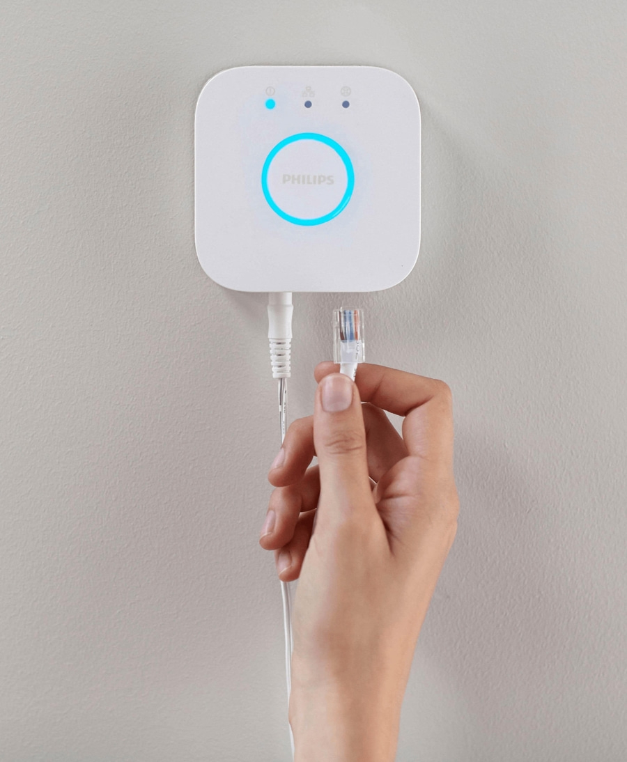 Philips Bridge mit Hand und Kabel an der Wand. Netzwerkanschluss.