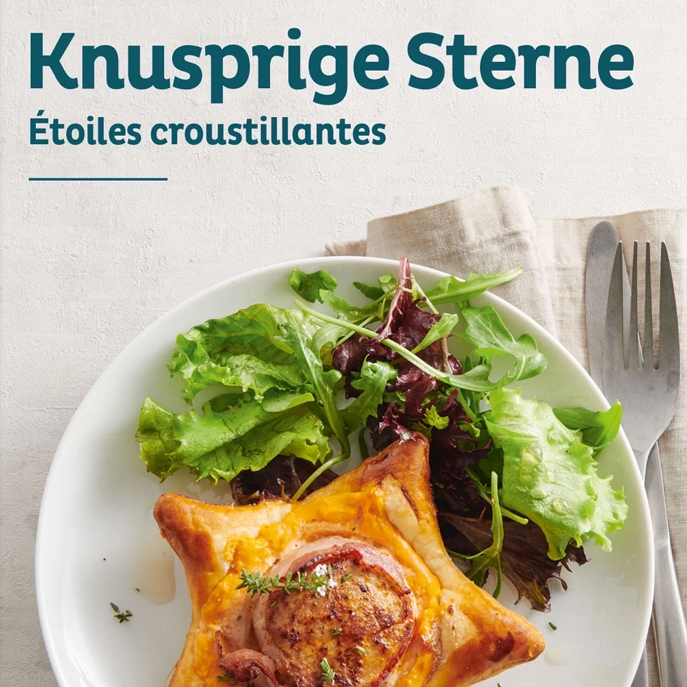 Knusprige Sterne mit Salat auf einem Teller, Gabel und Messer