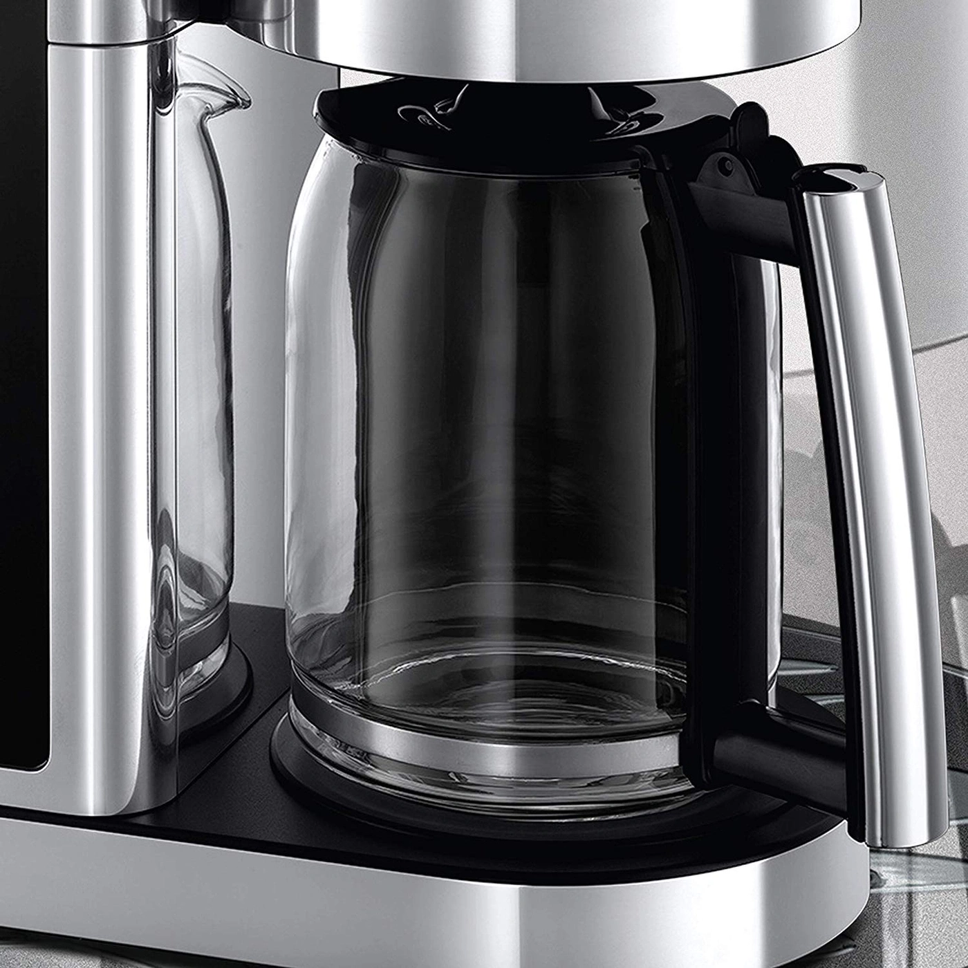 Eine Nahaufnahme einer Kaffeemaschine mit einem klaren Glaskrug und silbernen Akzenten.