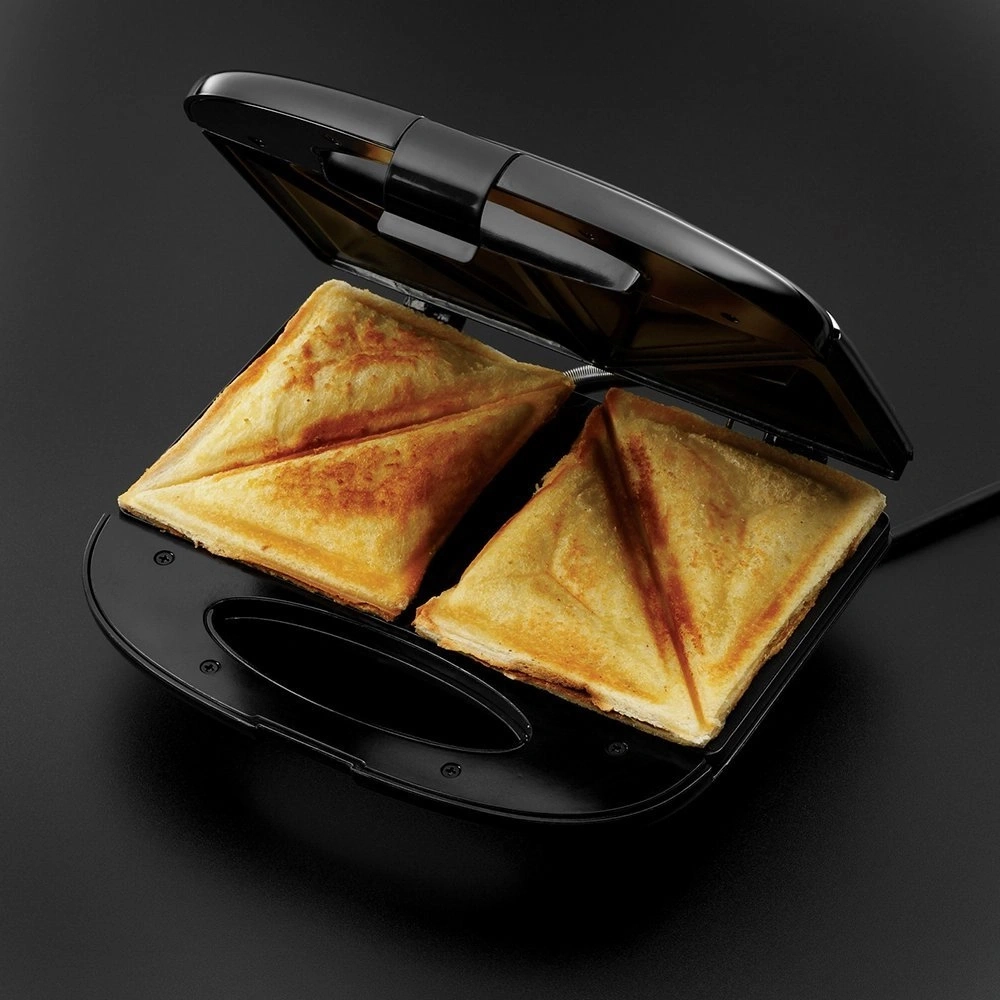 Sandwich-Toaster mit zwei goldenen Sandwiches auf schwarzem Hintergrund