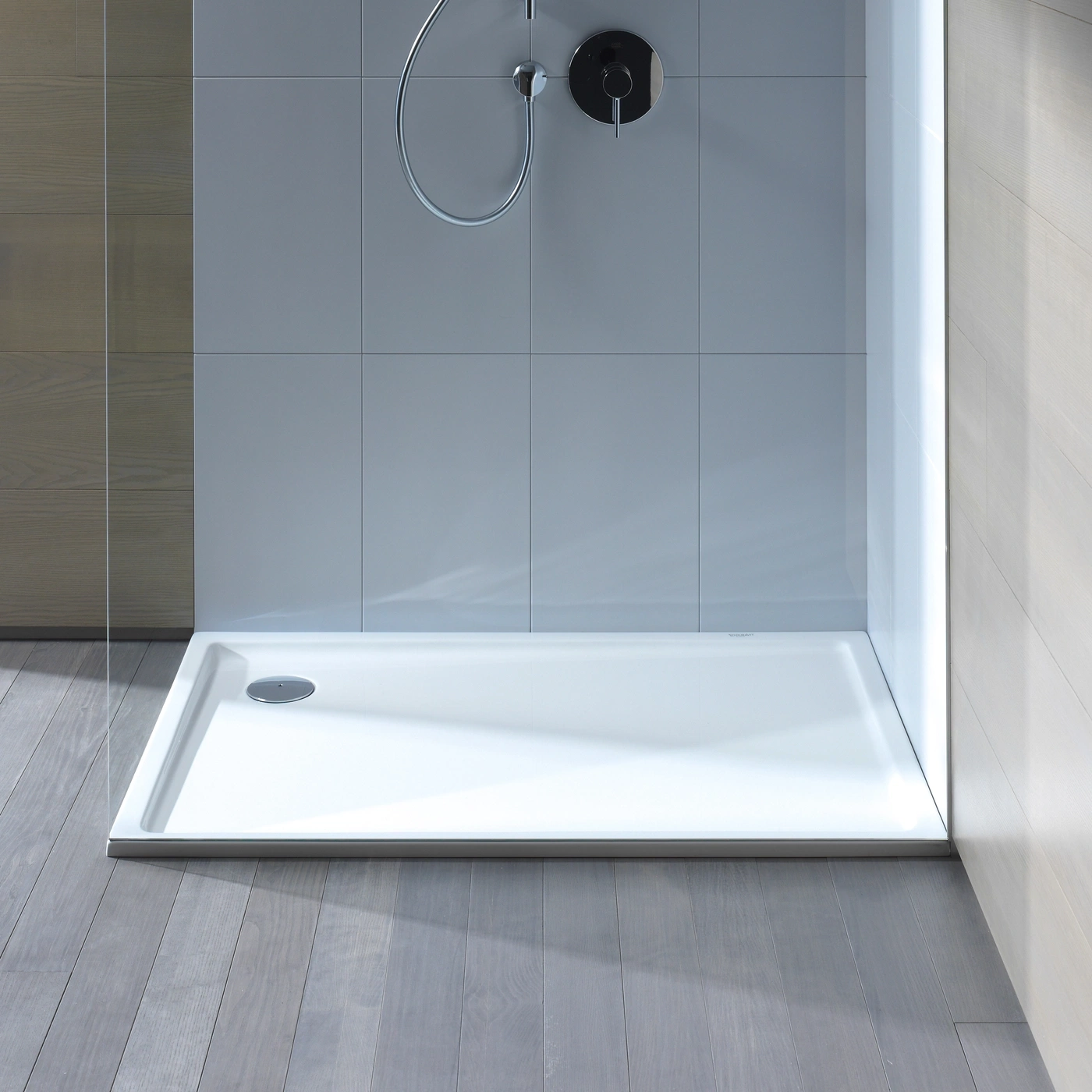 Duschkabine mit weißer Duschtasse und grauen Holzböden. Badezimmer-Design.