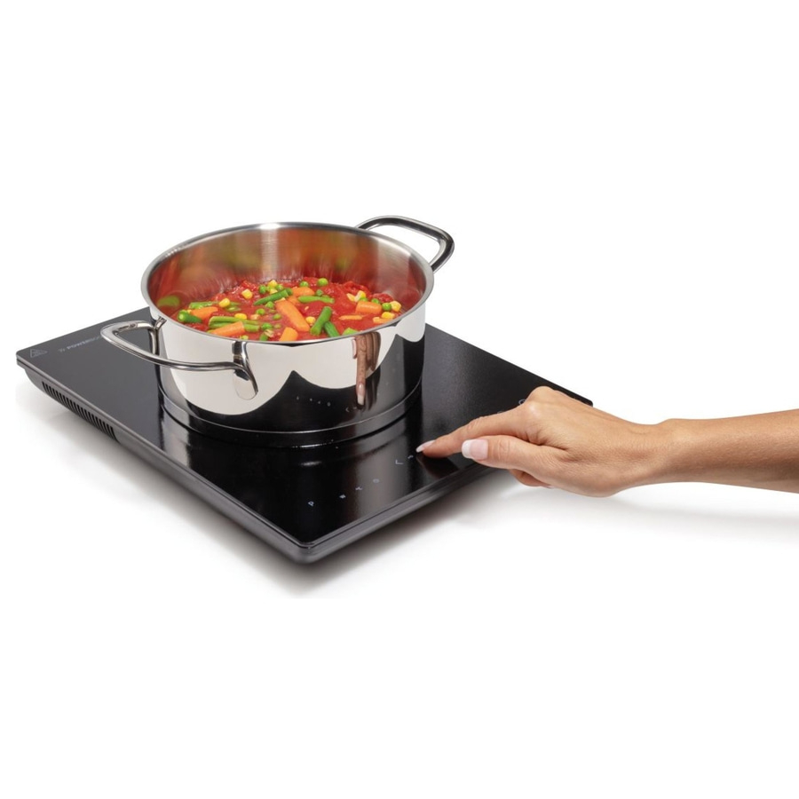 Induktionskochfeld mit Topf und Gemüse, Hand berührt Bedienfeld