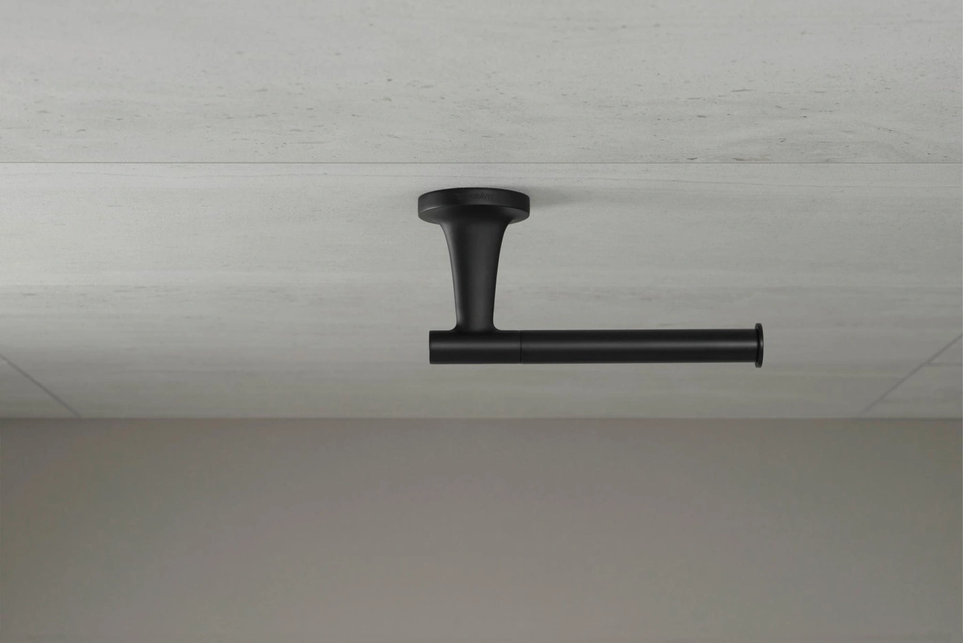Schwarzer Toilettenpapierhalter an einer grauen Wand. Badezimmer-Dekoration.