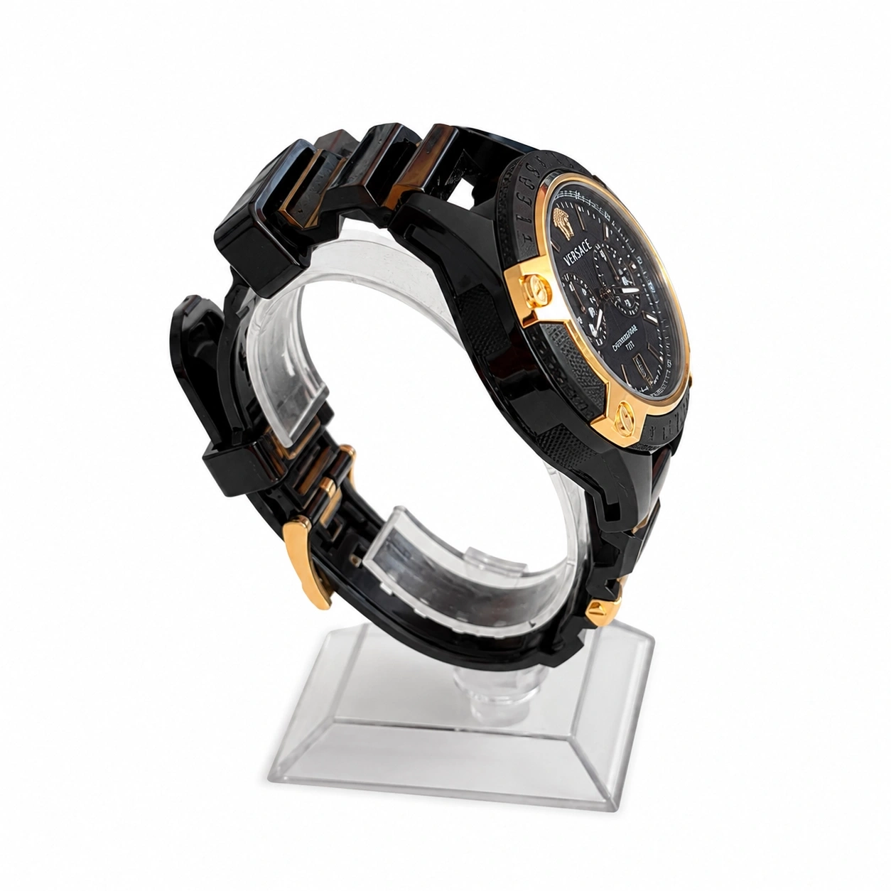Ein schwarzes Versace-Armbanduhr mit goldenen Akzenten auf einem transparenten Ständer.